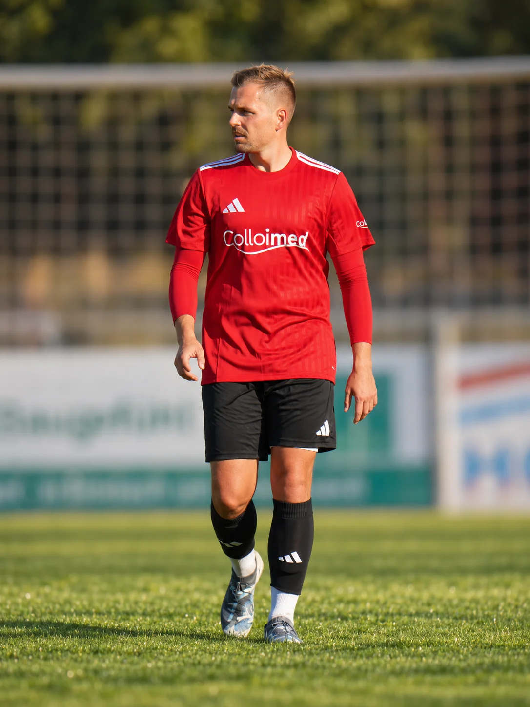 Spieler im roten Colloimed-Trikot steht auf dem Fußballplatz
