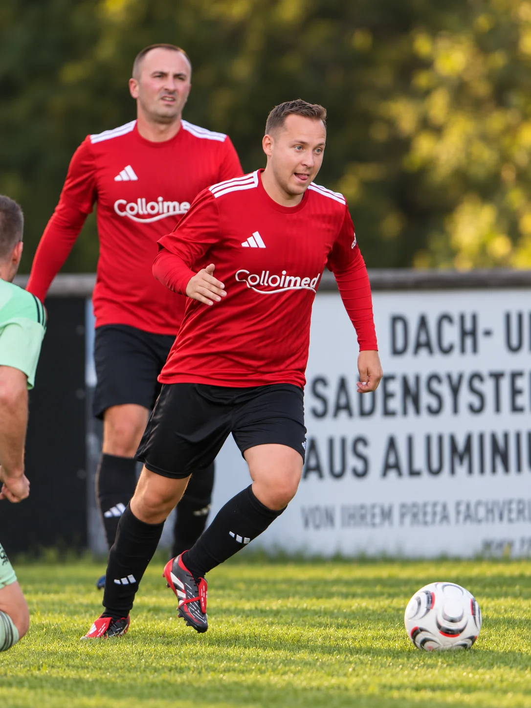 Zwei Fußballspieler in roten Colloimed-Trikots während des Spiels